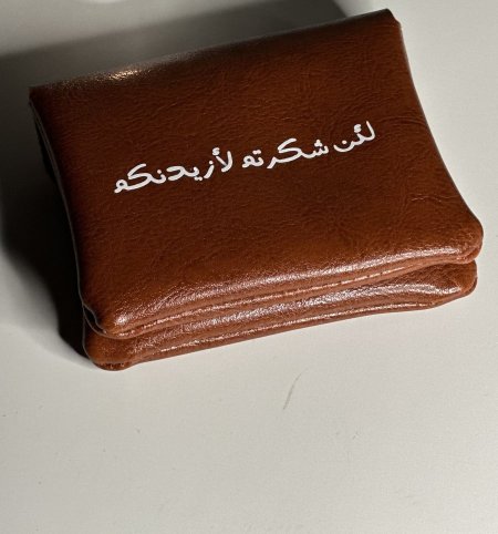 محفظة جلدية مع كتابة "لئن شكرتم لأزيدنكم" 